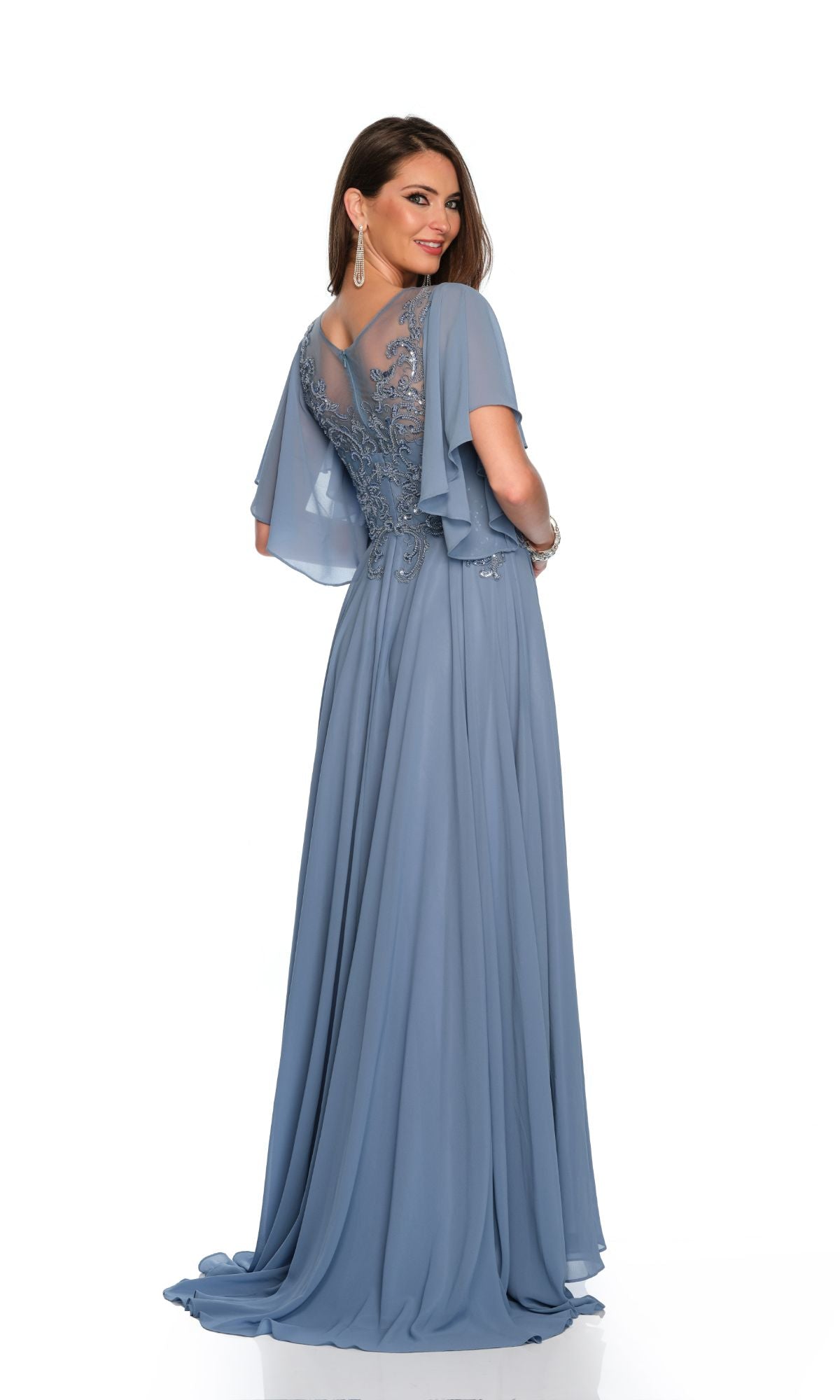 A woman models the Dave & Johnny Long Prom Dress 11676, a floor-length light blue gown with a sheer embroidered back and flutter sleeves, set against a white background.
